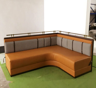 L-shape upholstered restaurant booth with houndstooth back and metal rail by Dejell