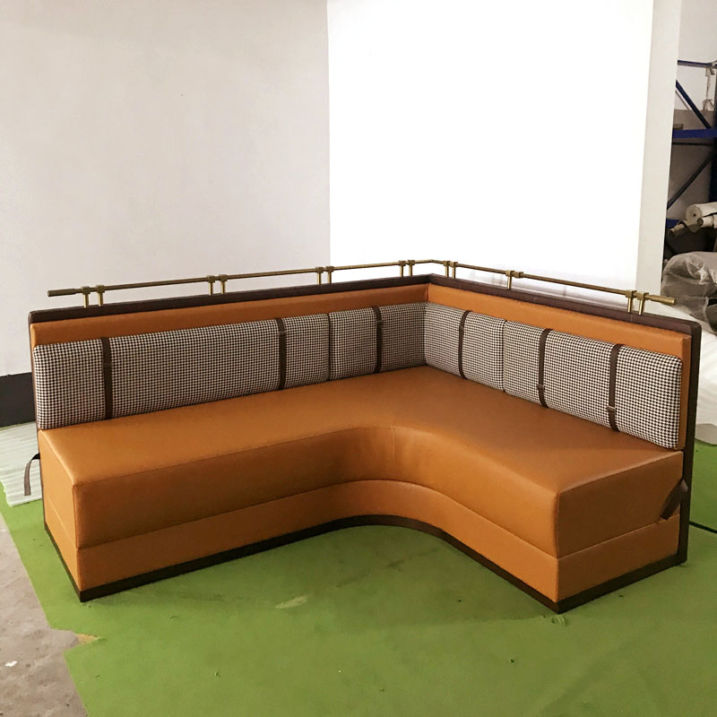 L-shape upholstered restaurant booth with houndstooth back and metal rail by Dejell