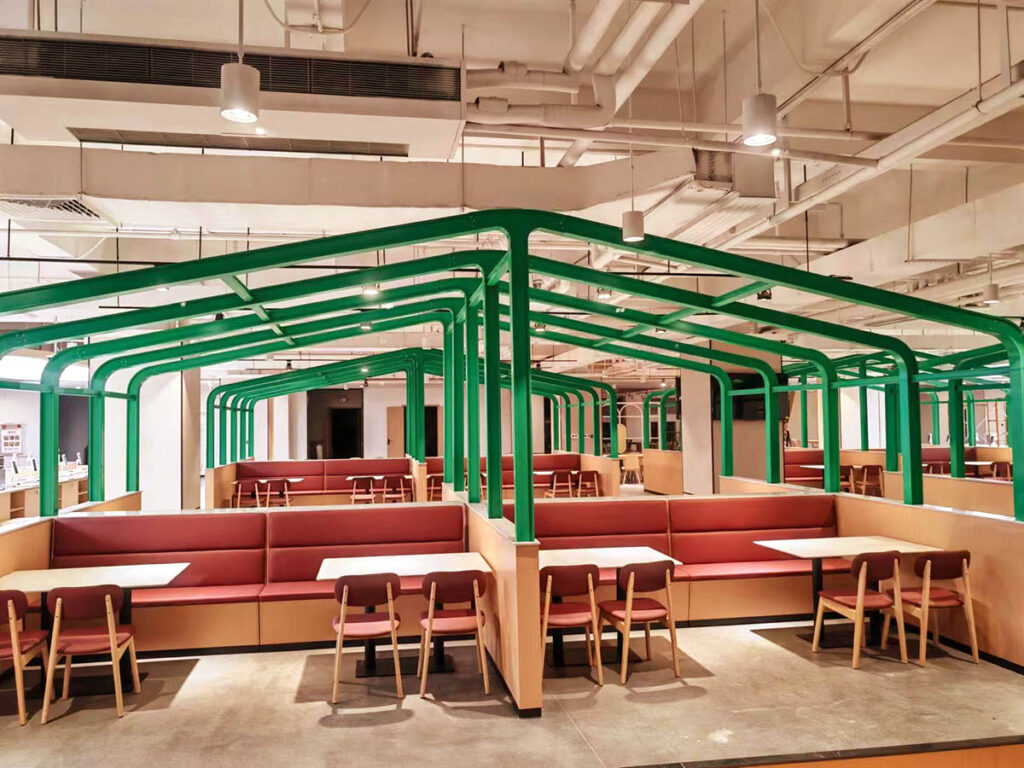 Custom canteen booth seating with green metal frame dividers by Dejell