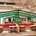 Custom canteen booth seating with green metal frame dividers by Dejell