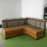 L-shape upholstered restaurant booth with houndstooth back and metal rail by Dejell