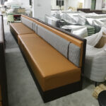 Multiple restaurant booth units with caramel leather and houndstooth back in factory