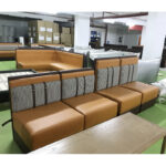 Modular restaurant booth seating with houndstooth back and leather strap detail by Dejell