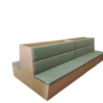 double-sided restaurant booth seating with sage green upholstery and wood frame by Dejell
