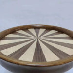 Close-up of sunburst ash wood veneer tabletop with alternating light and dark pattern