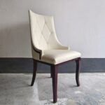 Side view of diamond tufted restaurant chair with curved ash wood legs