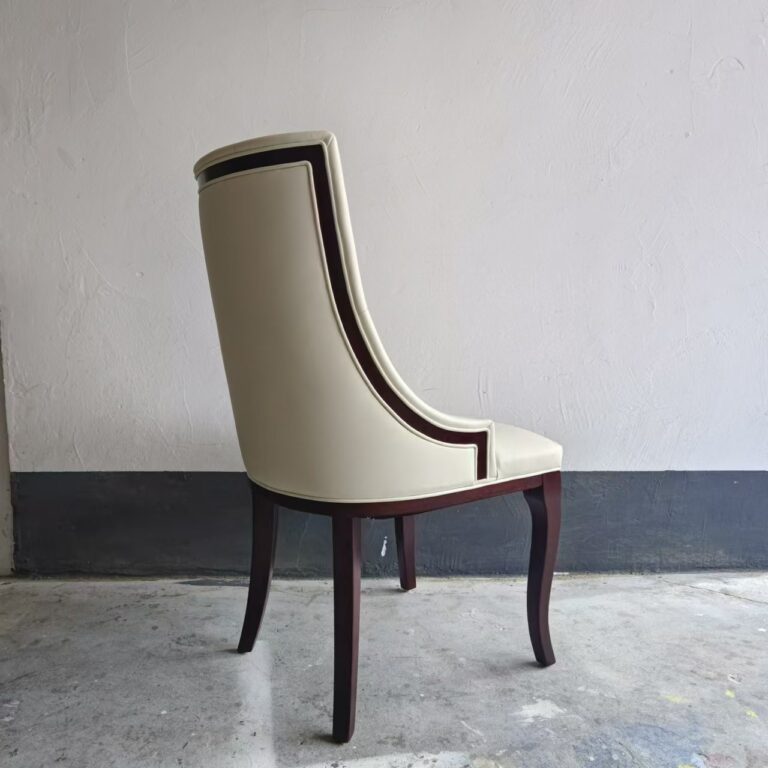 Close-up of white ash wood frame and curved leg detail on tufted dining chair