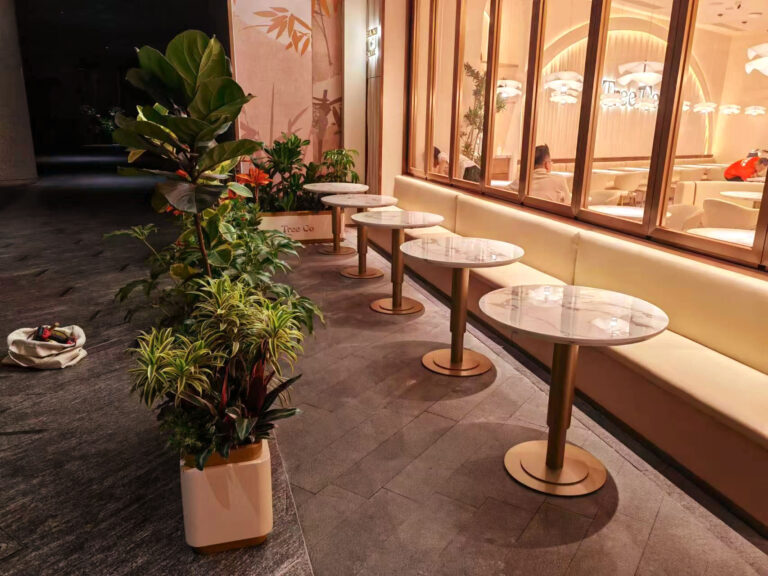 Restaurant exterior with custom outdoor planters and dining tables by Dejell at night