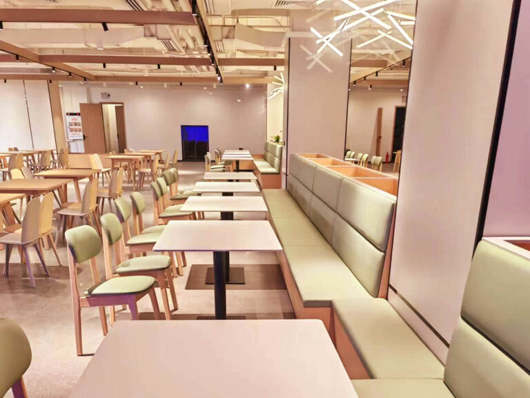 Mint green booth seating with matching dining chairs in corporate canteen by Dejell