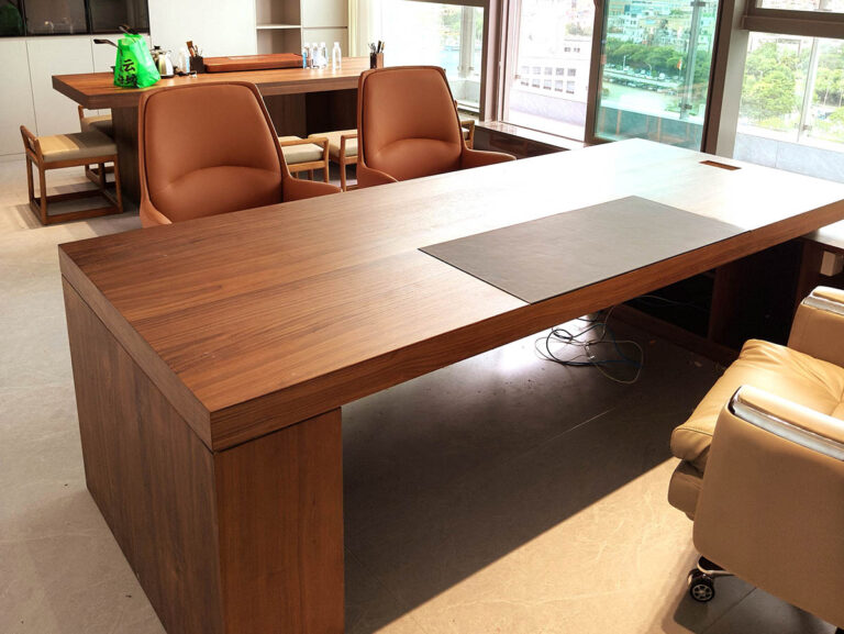 Custom L-shaped walnut executive desk with leather visitor chairs in chamber of commerce office by Dejell