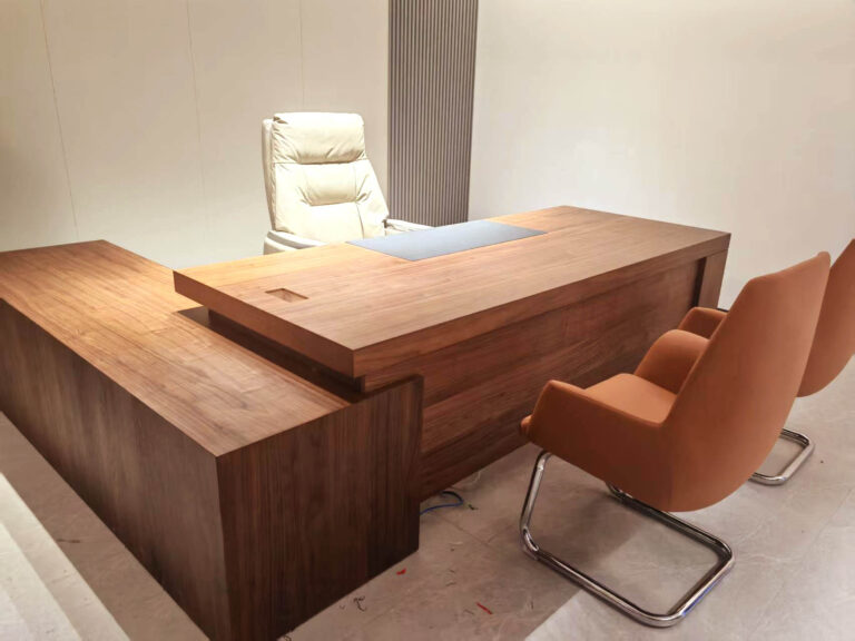 Custom L-shaped walnut executive desk with leather visitor chairs in chamber of commerce office by Dejell