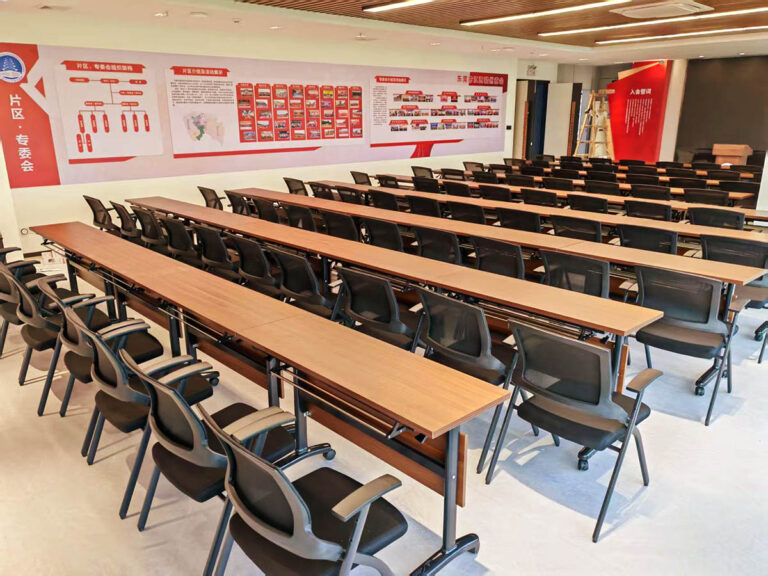 Training hall with modular long tables and mesh rolling chairs by Dejell