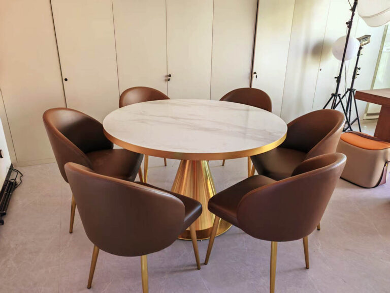 Round marble dining table with gold base and leather chairs by Dejell