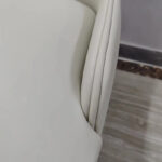 Detail of cream white PU leather wraparound backrest with center stitch line on dining chair by Dejell