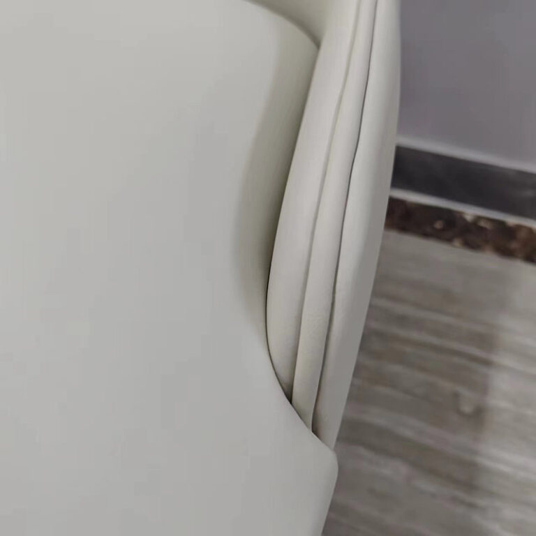 Detail of cream white PU leather wraparound backrest with center stitch line on dining chair by Dejell
