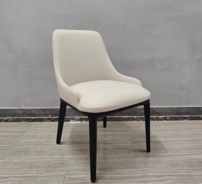 Modern cream white restaurant chair showing sculpted backrest and black wood legs from angled view by Dejell