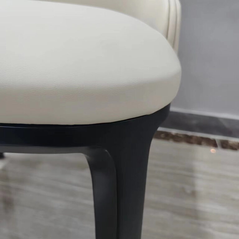 Seat cushion and black solid white ash wood leg connection detail on cream white dining chair by Dejell
