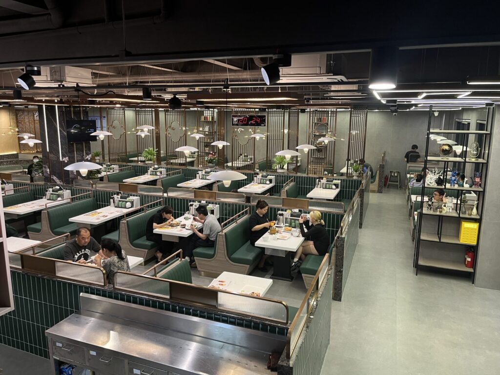 Blue upholstered restaurant booth seating at Tan Shijie