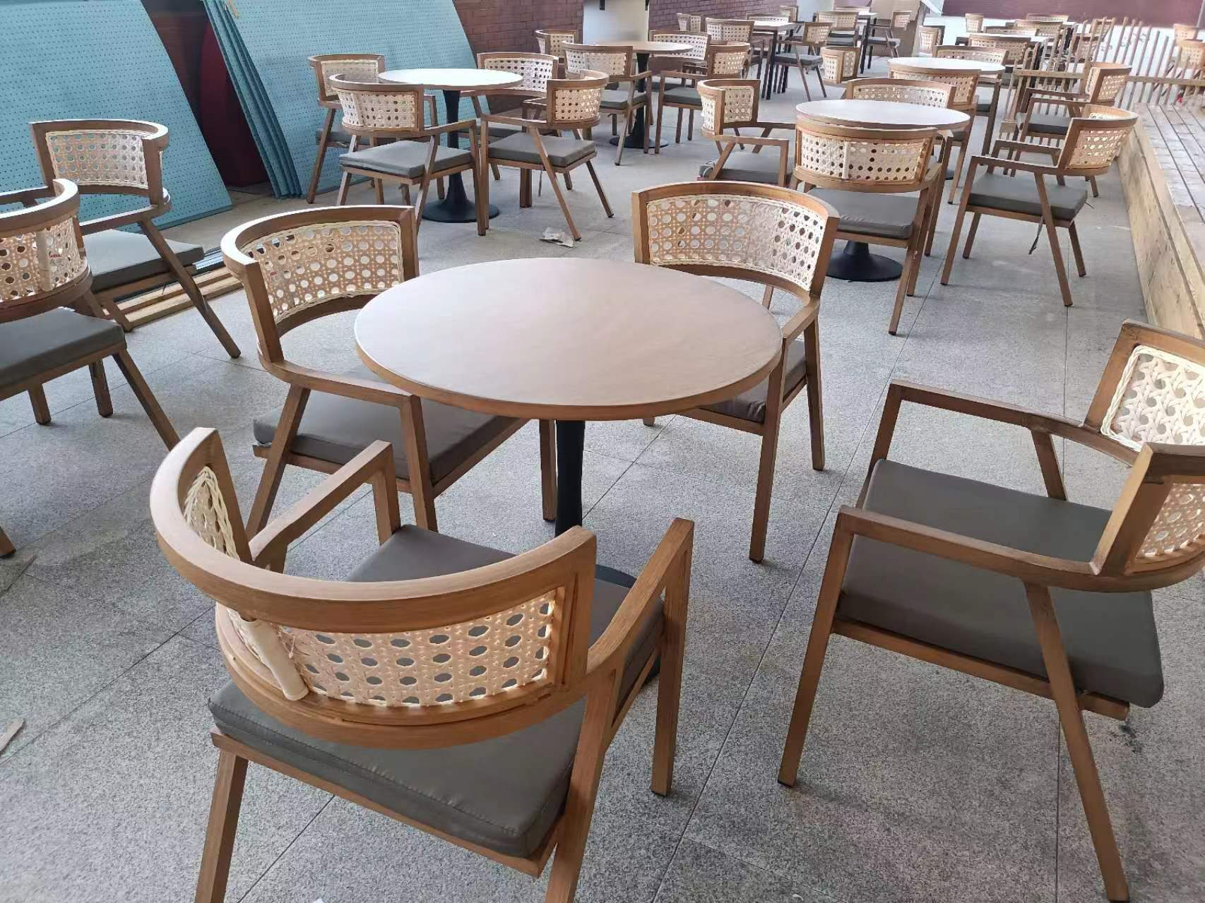 Round pedestal tables with rattan-back chairs on the terrace