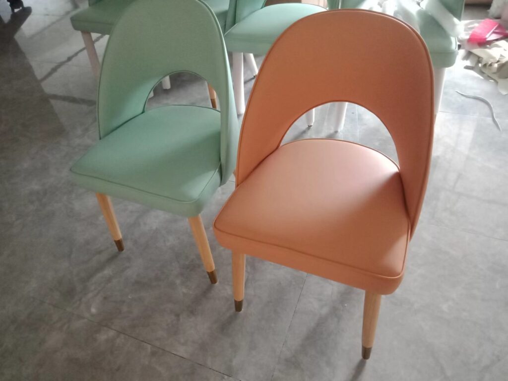 Mint green and peach upholstered dining chairs with wood legs for campus canteen