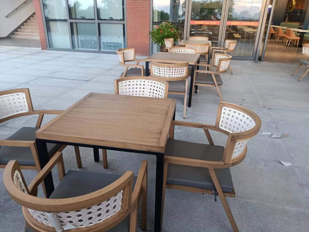 Teak-look tables with rattan-back chairs on Hainan University outdoor terrace